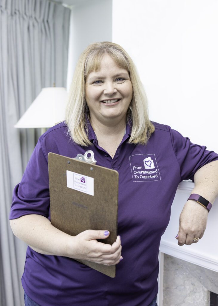 Hilda Rodgers is dressed in purple branded gear holding a clipboard ready to help you organize your home.