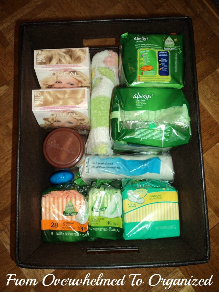 Linen closet after organization. Toiletires organized in a basket. 
