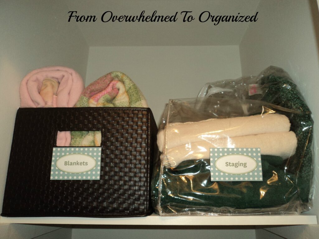 Linen closet after organization. Blankets labeled in a bag and basket. 