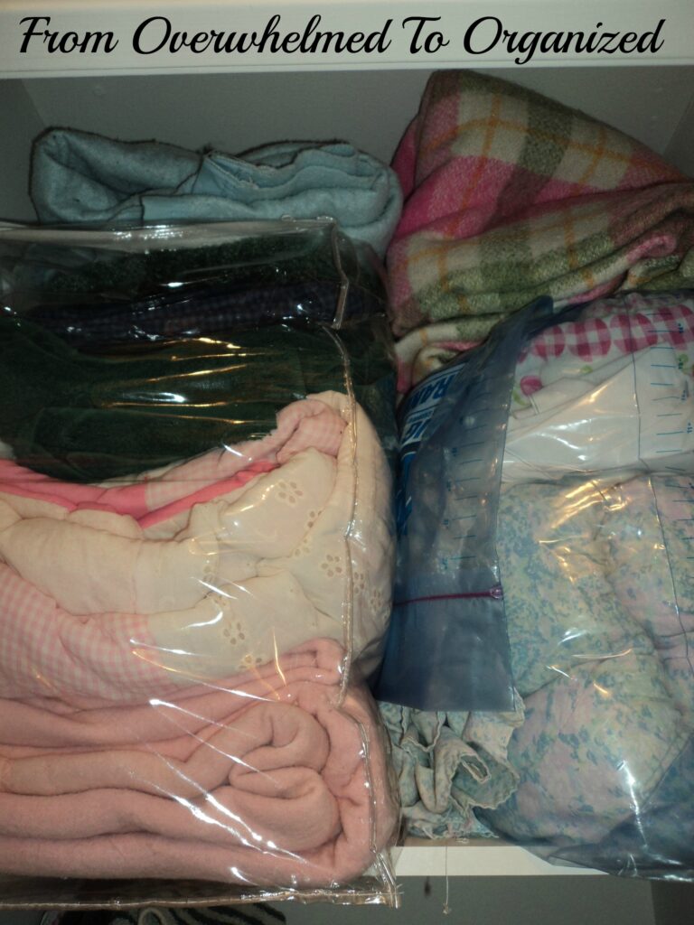 Linen closet before organization. Bags filled with linens stuffed on shelf. 