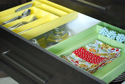 Drawer organizers holding cutlery napkins and napkin holder. 
