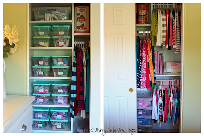 Organized kids closet with hanging clothes and plastic bins. 