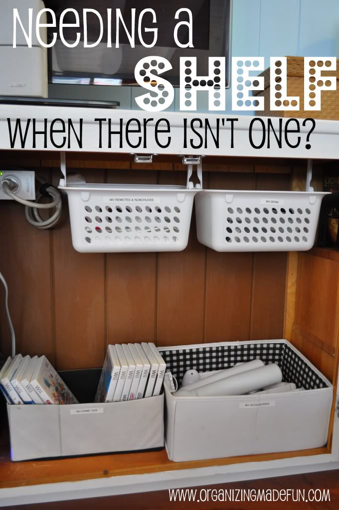 Needing a shelf when there isn't one? www.organizingmadefun.com
Floating bookshelf hung under television with two hanging hanging white plastic baskets. Two beige fabric baskets on shelf below holding Wii games and accessories. 
