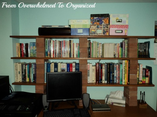 From Overwhelmed to Organized. Organized desktop with computer. Two levels of bookshelves sit on top of desk with labelled boxes on top. 