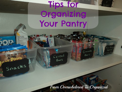 Tips for organizing your pantry. From Overwhelmed to organized. Plastic bins on pantry shelves labeled with black chalkboard labels. Bins are filled with snacks.