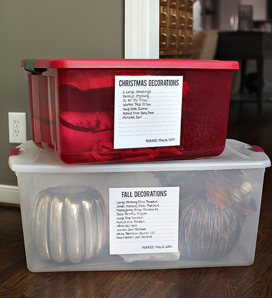 Stack of clearly labeled rubbermaid boxes. A red box holds Christmas decorations and a clear box holds halloween decor.