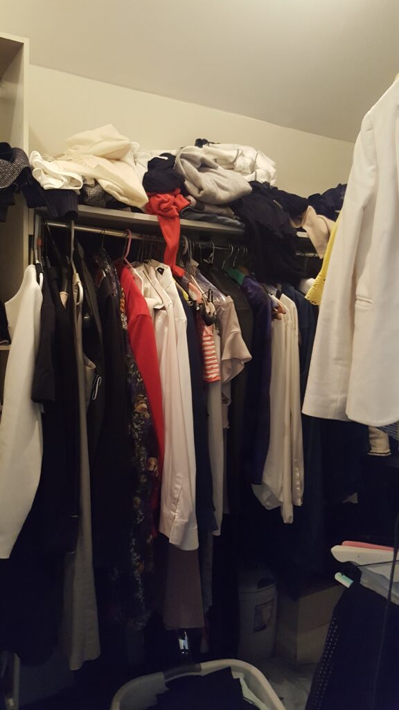 Cluttered closet before organizing.