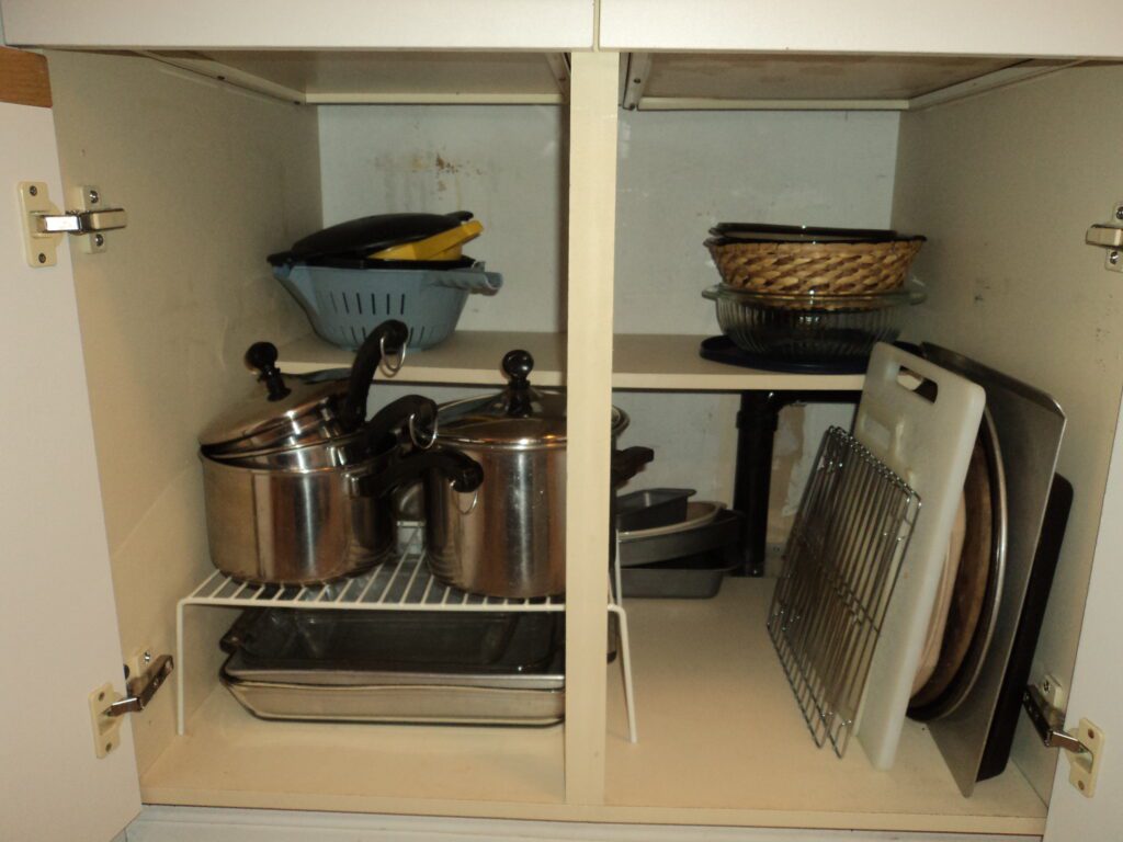 Decluttered and organized pot and pans cabinet.
