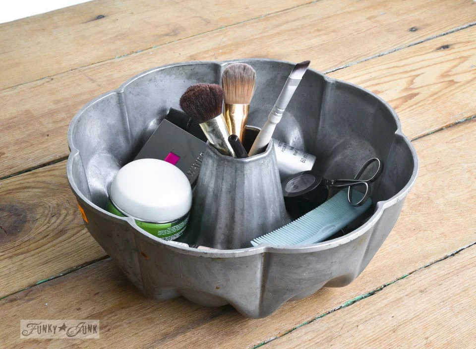 Funky Junk. Rustic metal bundt pan used as a bathroom tray holding makeup brushes and cosmetics.