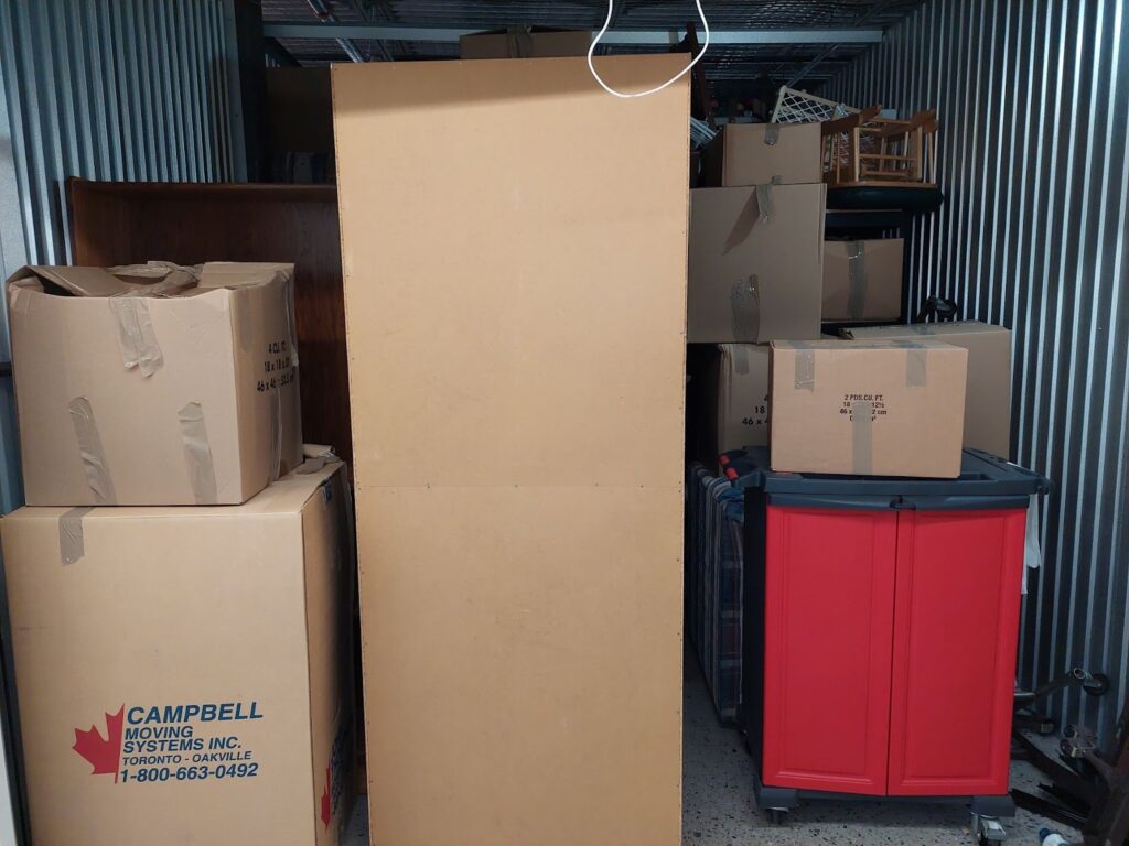 Storage unit filled with totes and cardboard boxes. 