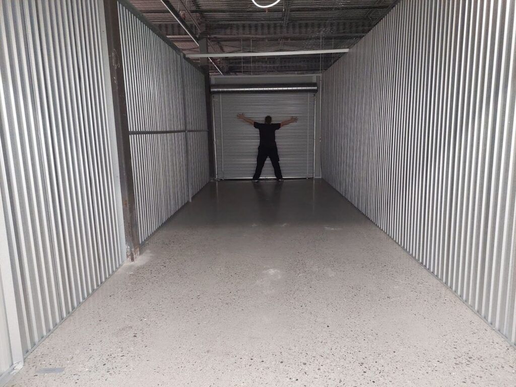 Person standing at the back of empty storage unit. 